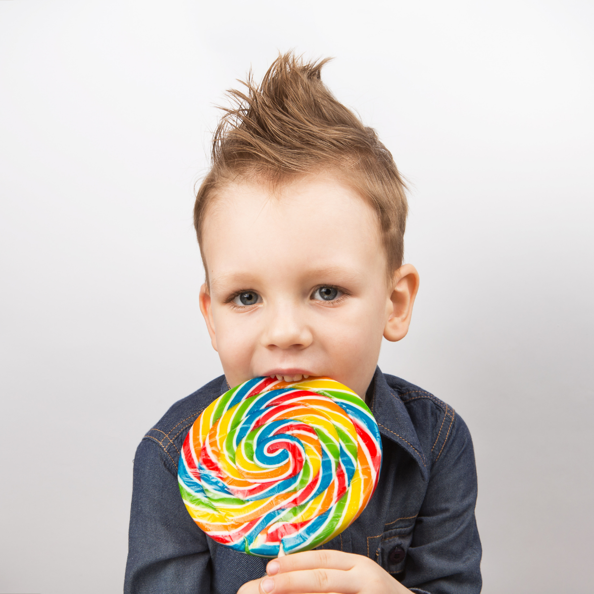 Young child holding a large colorful lollipop, representing the “candy store” temptation of shadow AI—showing how banning AI tools can backfire without education and governance.